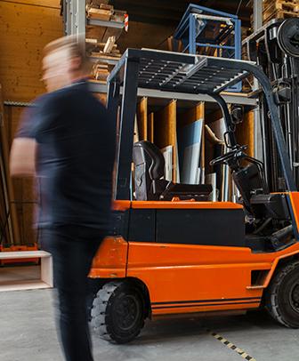 Picture of a Man standing next to the forklift